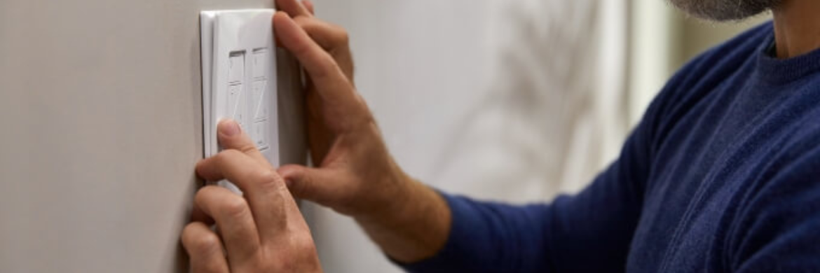 Man placing the light switch on the wall